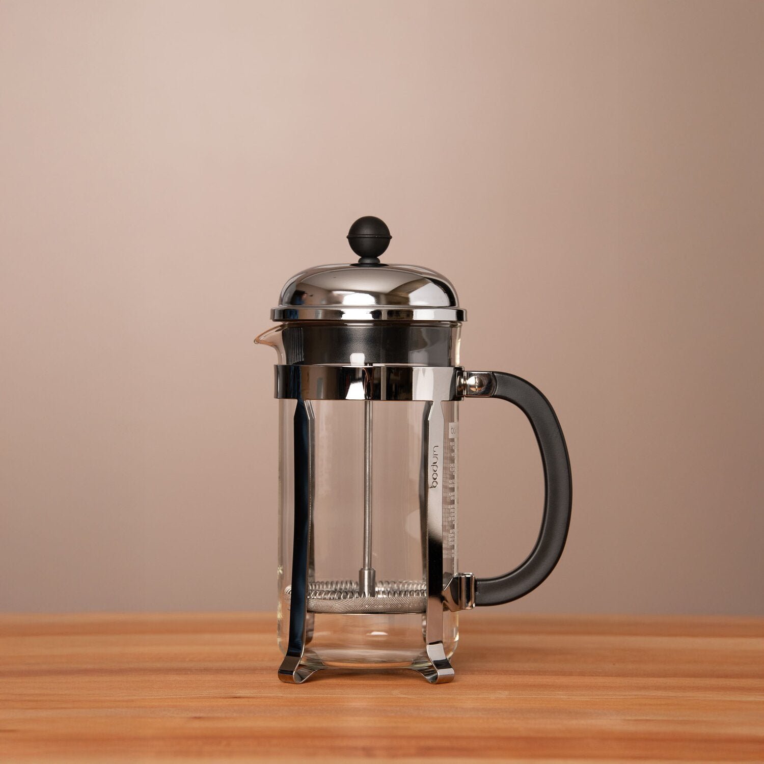 A French press carafe being safely placed on a heat resistant mat.